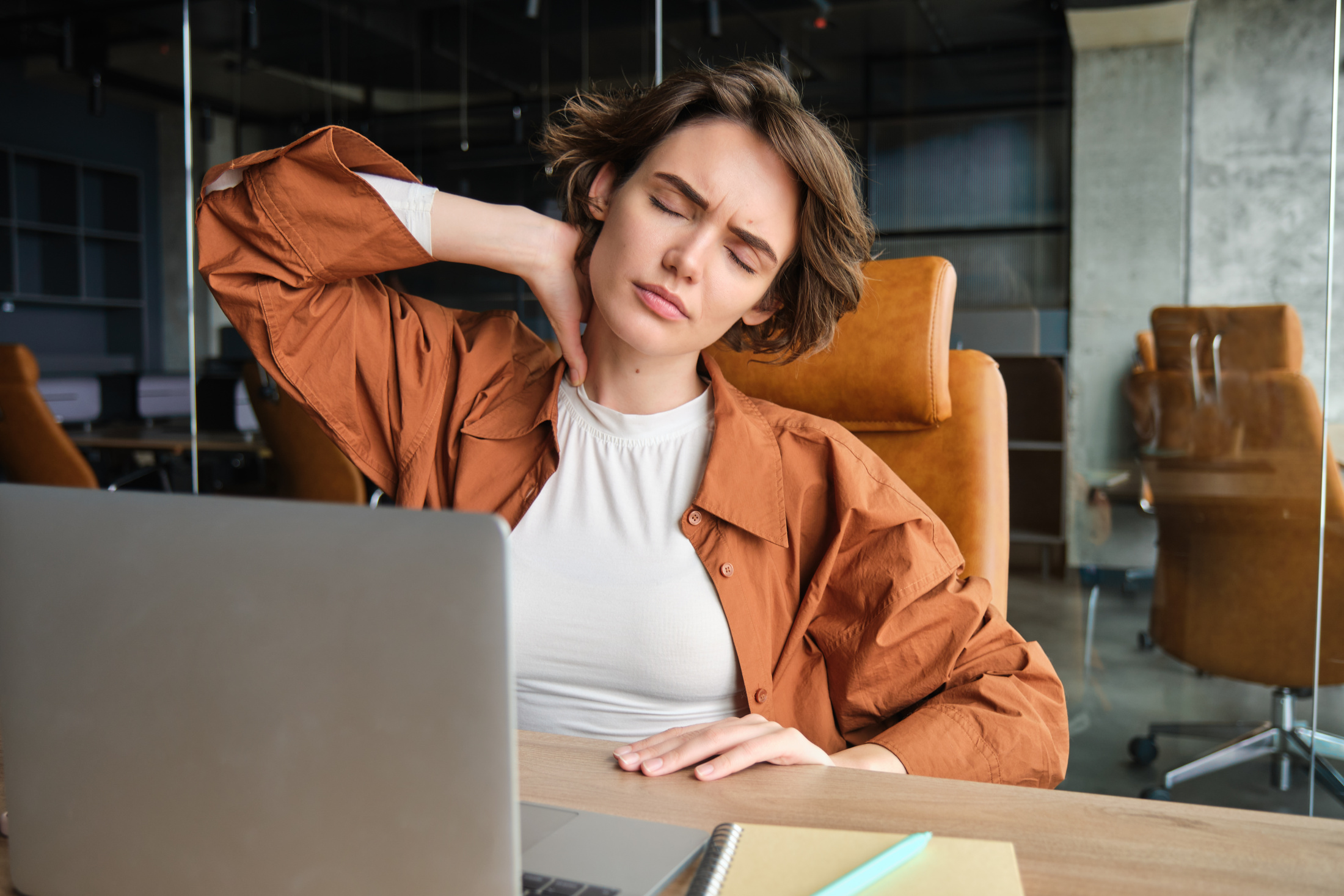Image woman with tired face sits with laptop office feels tension neck pain muscles
